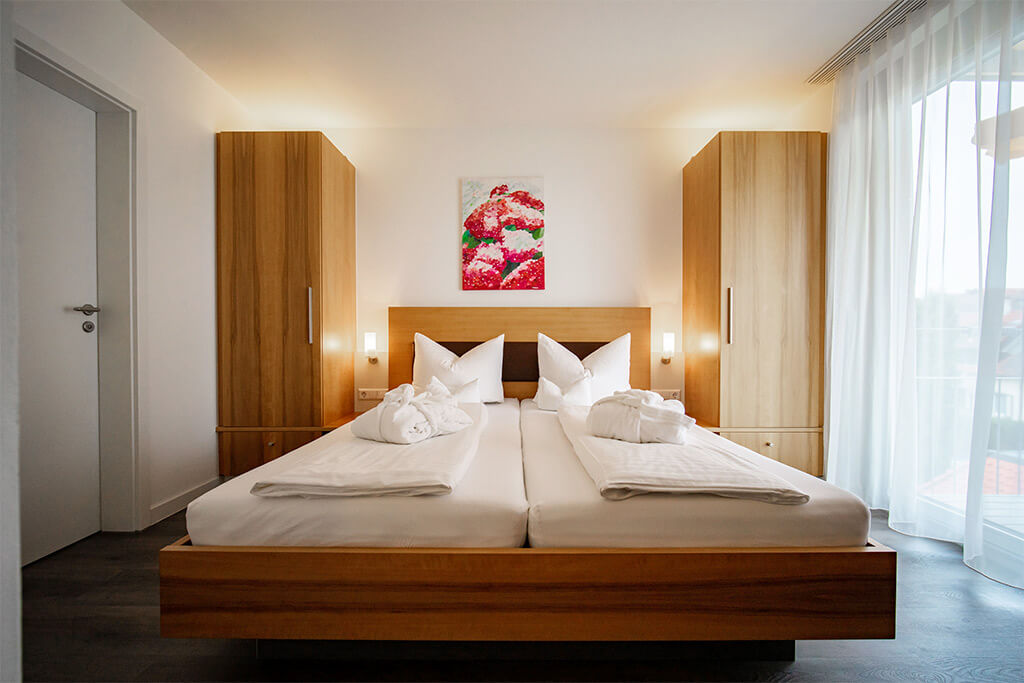 Helles Schlafzimmer mit Doppelbett und minimalistischer Einrichtung