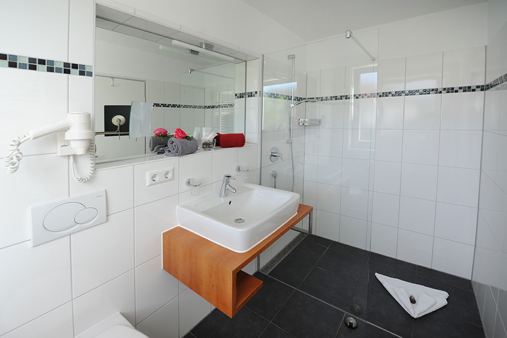 Helles Badezimmer mit Glasdusche, Waschbecken und modernem Design