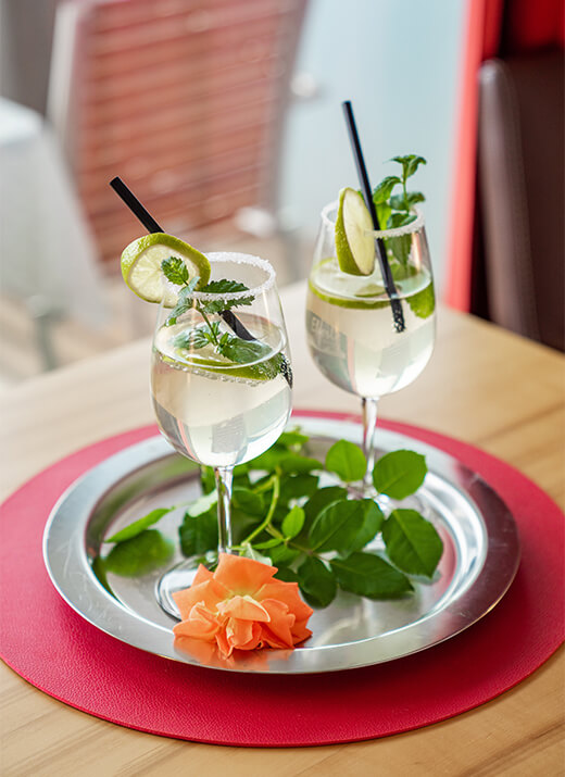 Zwei dekorative Getränke mit Limette und Minze auf einem Tablett