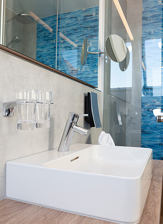 Modernes Waschbecken mit Spiegel und blauer Fliesenwand im Badezimmer