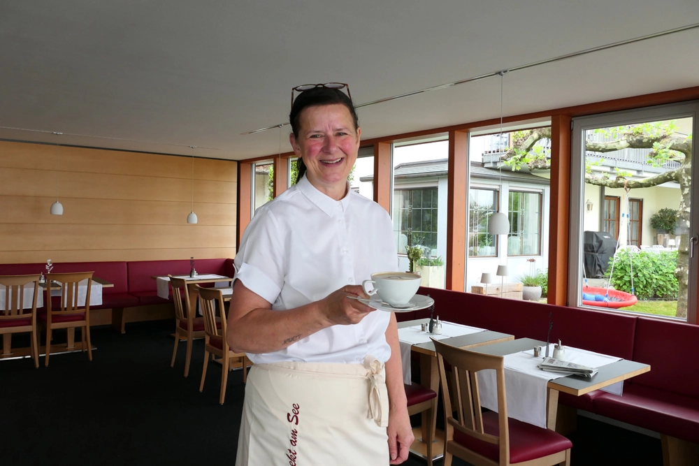 Mitarbeiterin Frühstücksservice serviert Cappucino